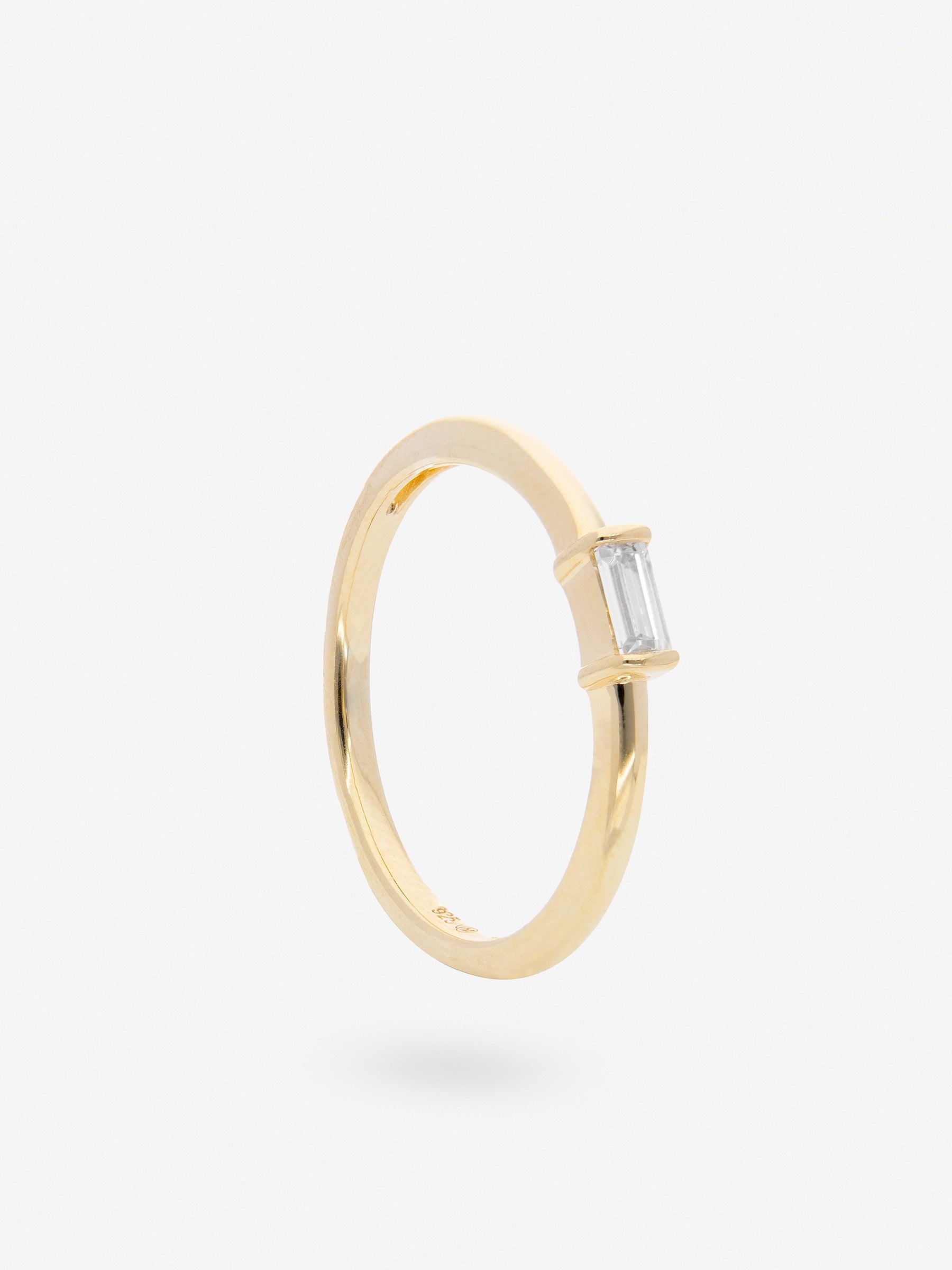 Anillo de plata simple con detalle de Topacio Blanco en forma rectangular chapado en oro.
