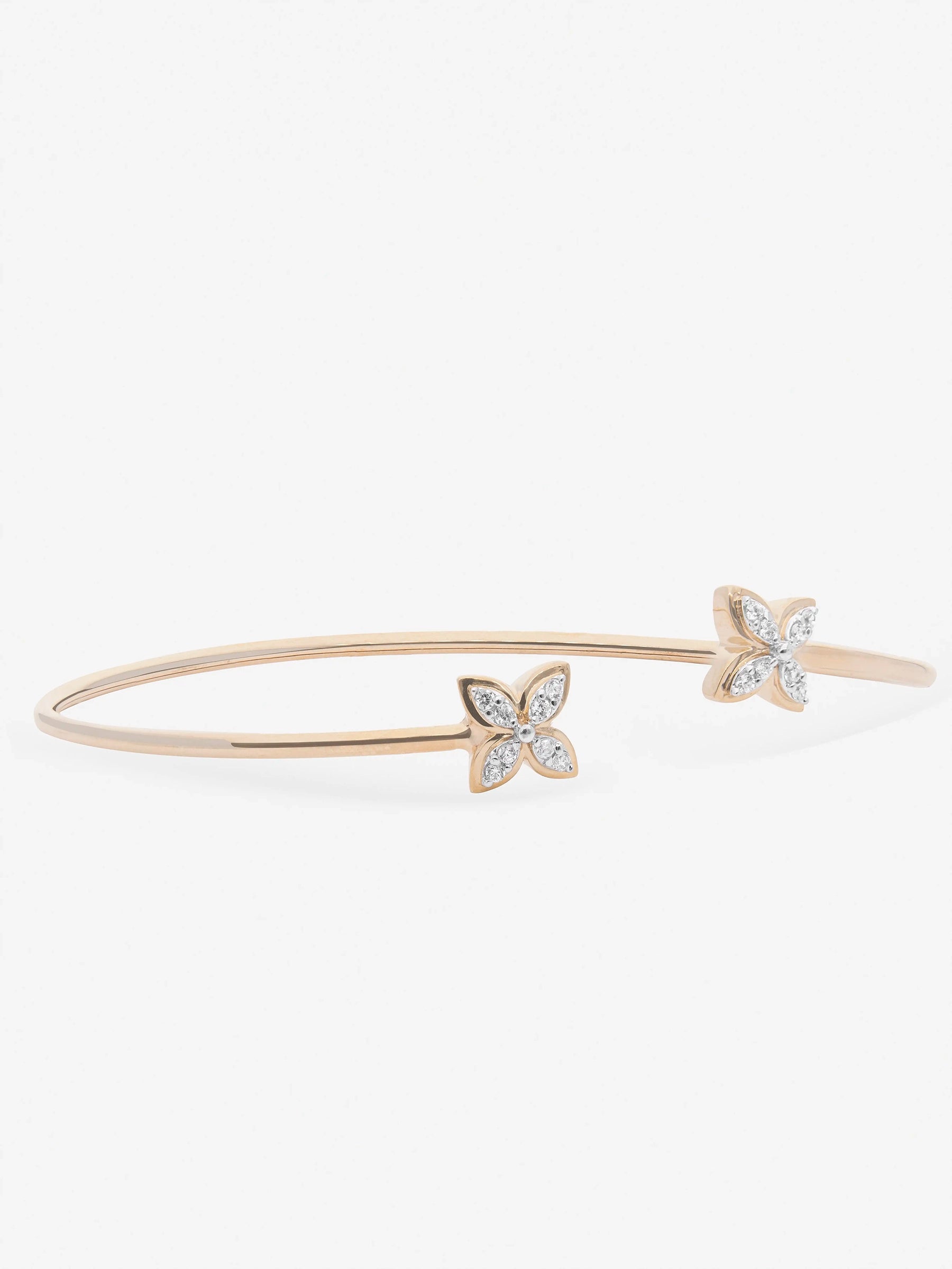 Brazalete abierto con extremos en forma de flores cubiertos de topacios blancos de frente.