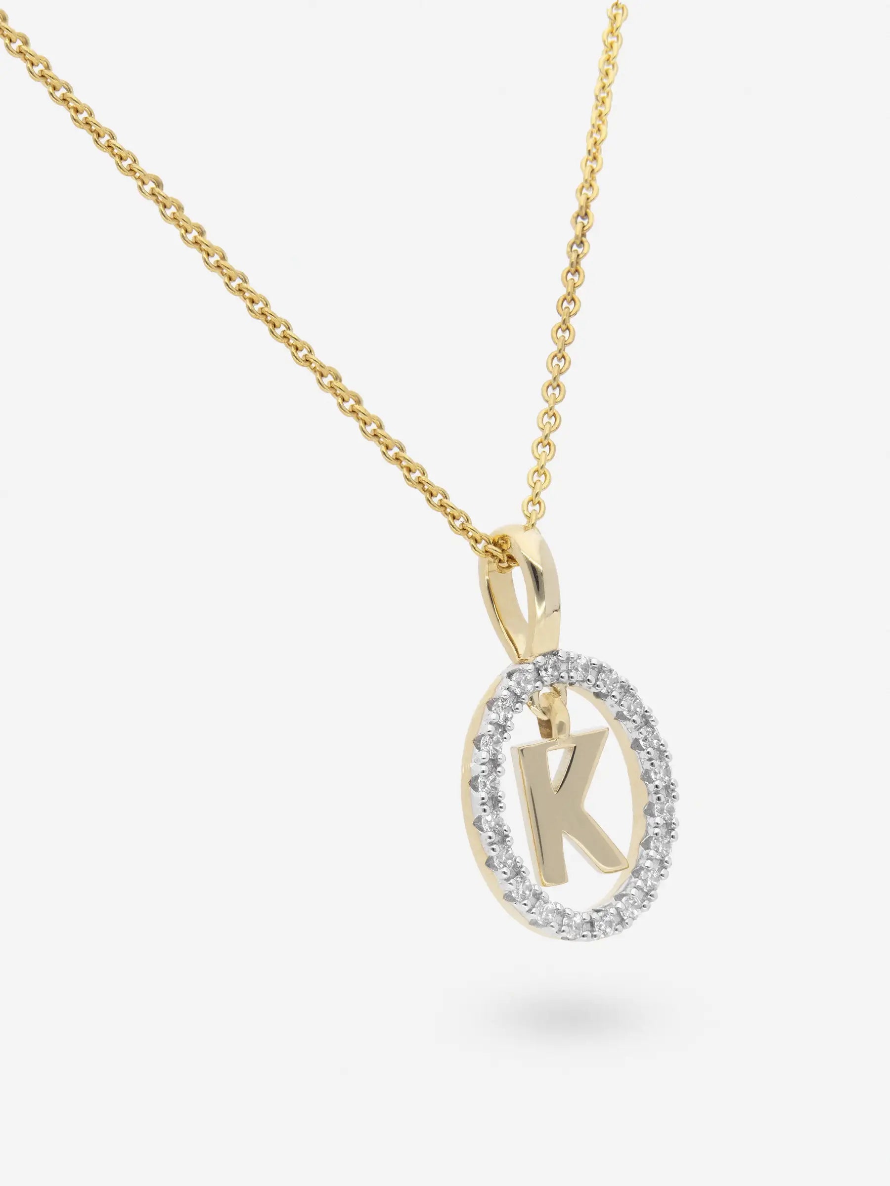 Collar realizado en plata chapada en oro amarillo con la inicial K dentro de un circulo de topacios blancos