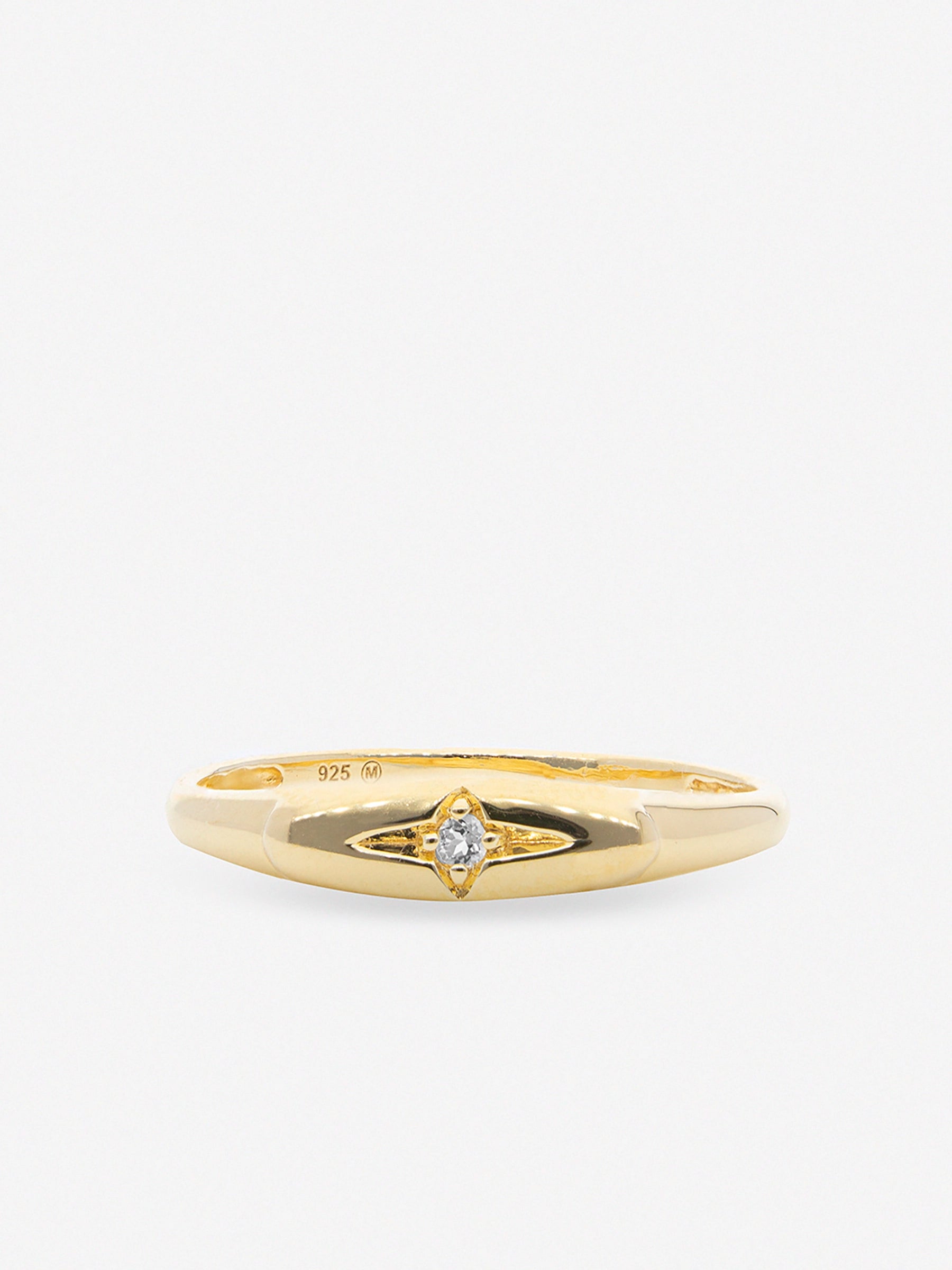 Anillo sello con forma ovalada y detalle de estrella en relieve con piedra de topacio blanco.