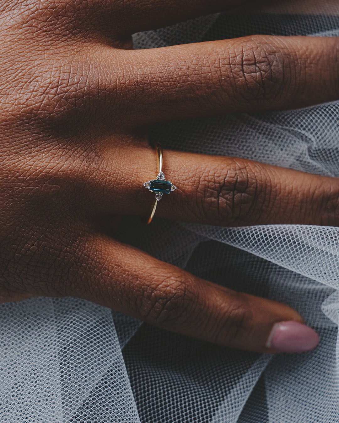 Mano con el anillo de Topacio Azul London y Topacio blanco