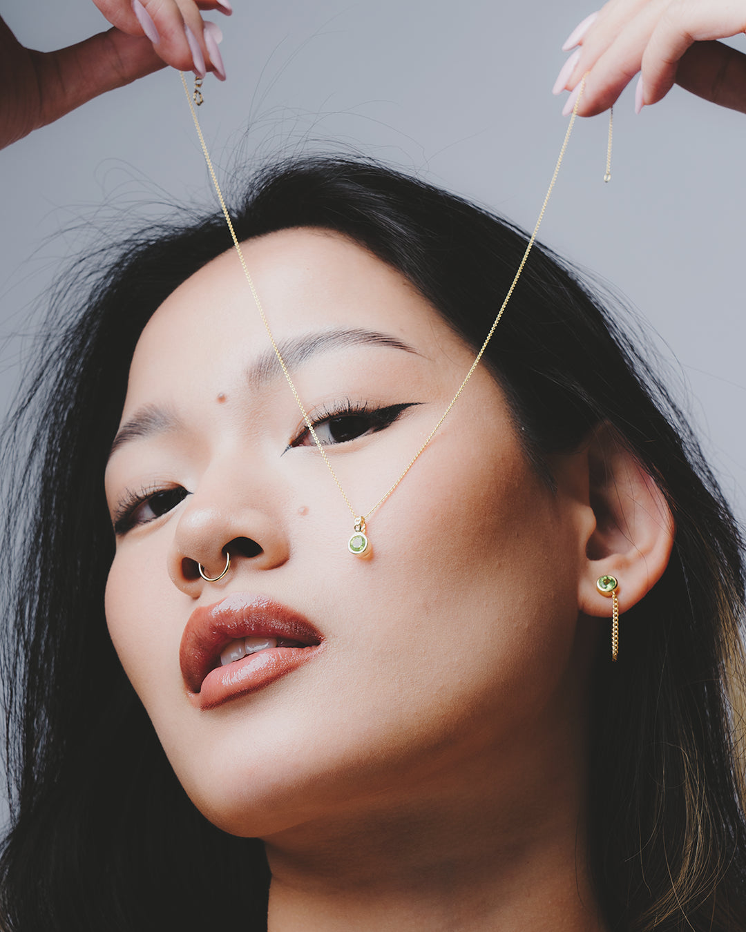 Modelo enseñando el colgante de peridoto circular con los pendientes a juego