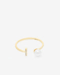 Anillo de plata chapada en oro. Aro abierto con una perla en uno de los extremos y una barra con cinco topacios en el otro.