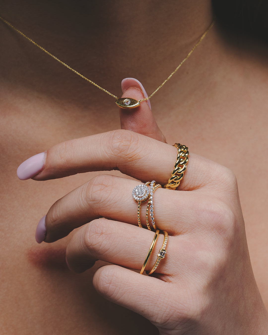 Mano con anillos de la colección enseñando un collar a juego